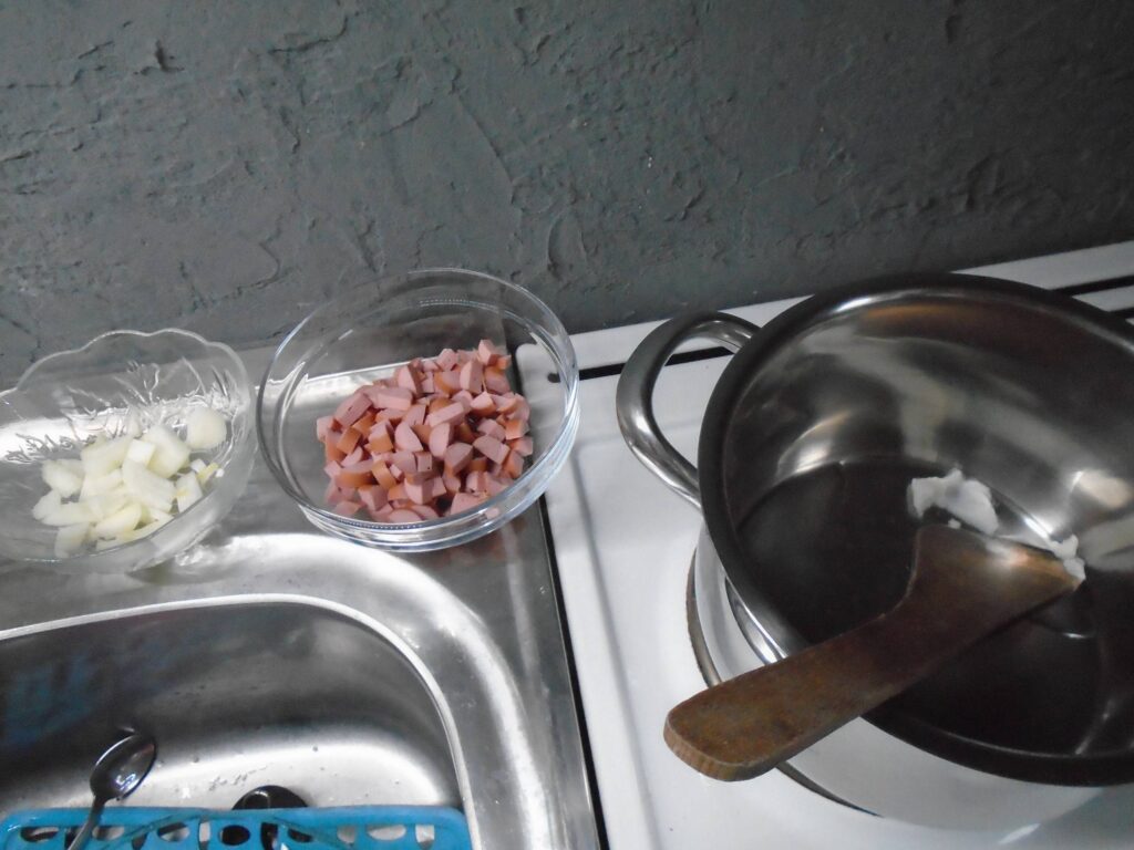 Frankfurt soup, we heat the lard, add the onion and sausages.